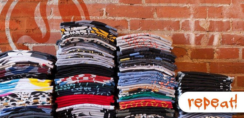 Stacks of t-shirts created by The Spirit Outfitters